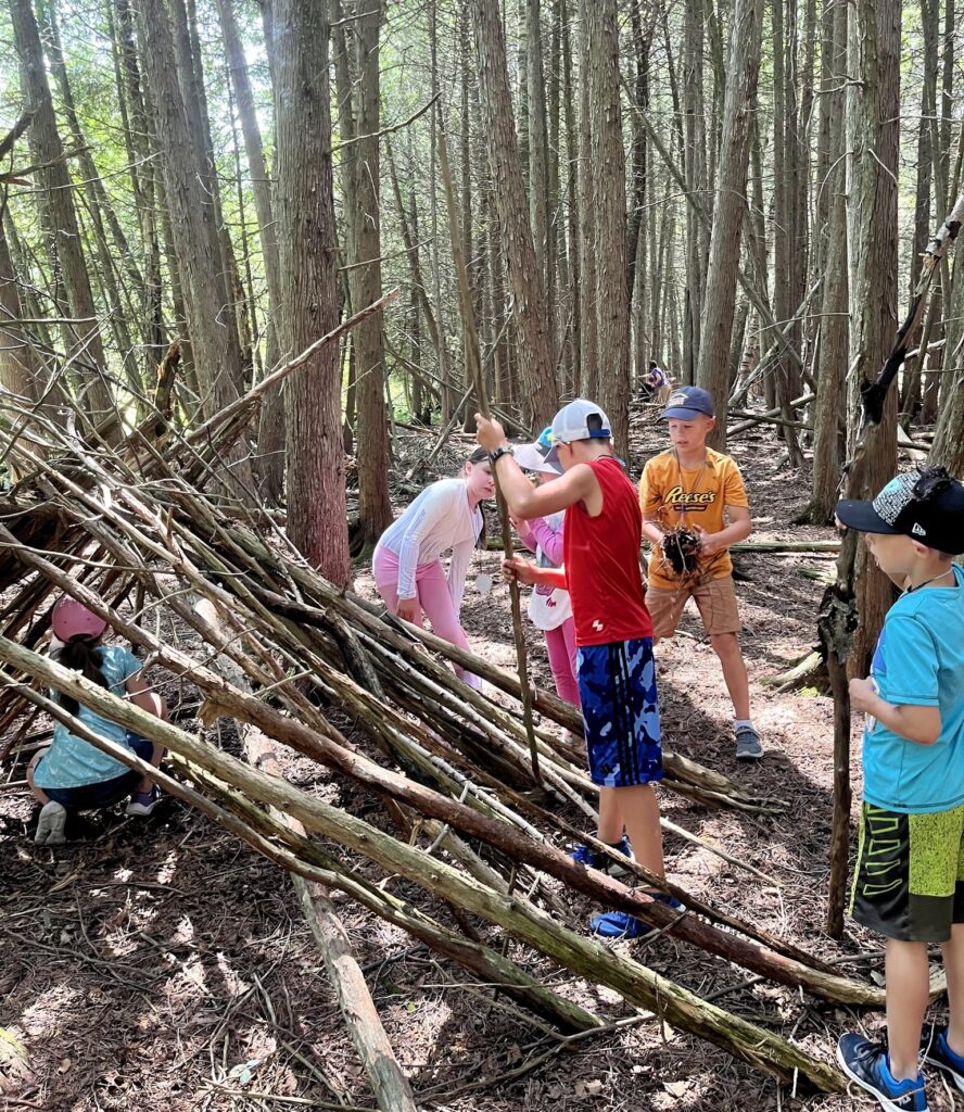 Campers building a fort in the forest.